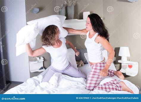 Two Attractive Women In Bed Having A Pillow Fight Stock Image Image