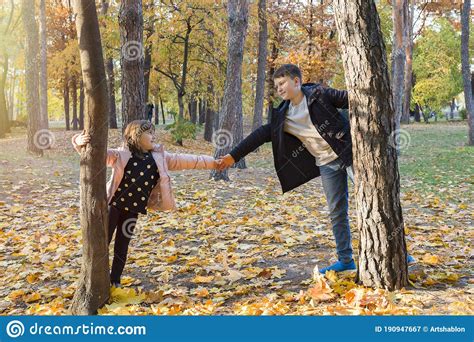 Children Play In The Autumn Park Autumn Foliage Golden Hour Stock