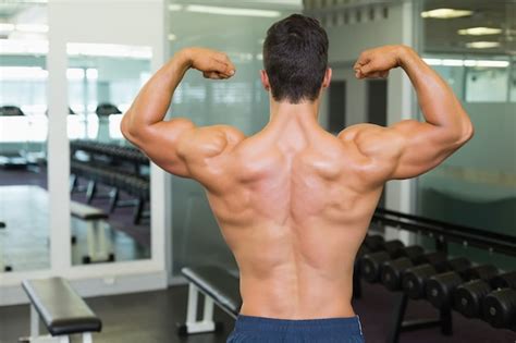 Premium Photo Rear View Of A Muscular Man Flexing Muscles