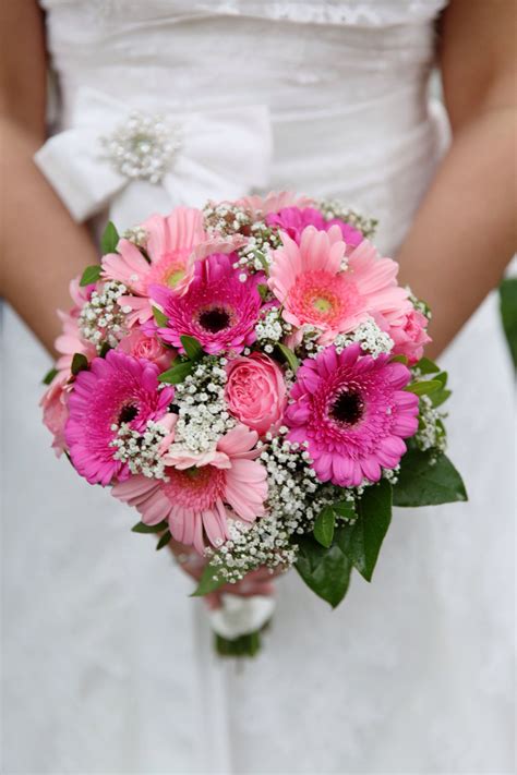 A Bride Holding A Bouquet Of Pink And White Flowers