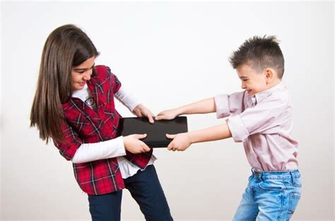 premium photo brother and sister fighting for laptop