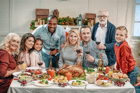 Large family celebrating Christmas with glasses of wine and looking at camera - Stock Photo ...