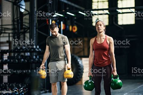 Young Athletes Using Kettlebells While Working Out In A Gym Stock Photo