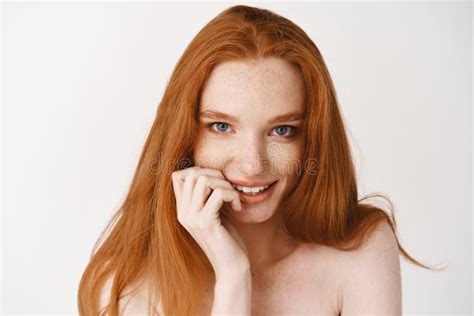 Close Up Of Flirty Redhead Woman With Pale Skin And No Makeup Biting Fingernail And Staring At