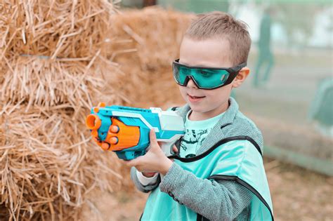 Small Preschooler Boy With Blaster Prepare For Attack And Play With