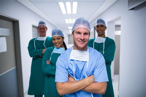 Portrait Of Nurse And Surgeons Standing In Corridor Photo From Pikwizard