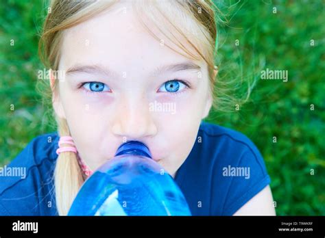 Close Up Portrait Of Adorable Girl With Blue Eyes Drinking Water From