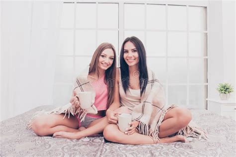 Two Sisters Sitting On Bed And Basking With Plaid And Coffee Stock Image Image Of Crossed