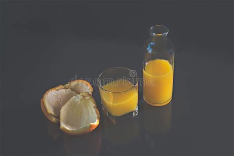 Orange Juice In A Glass Jar And Glass Orange Peels Are Next To It
