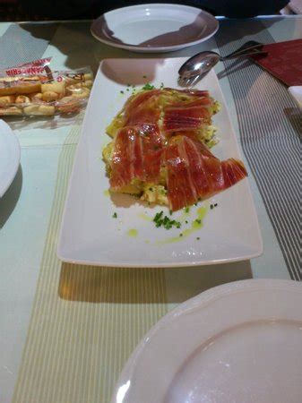 Revuelto de patatas a la antigua con huevos de granja y jamón de bellotas fotografía de