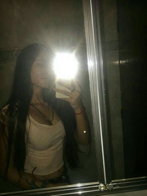 A Woman Taking A Selfie In Front Of A Mirror With A Light On Her Head