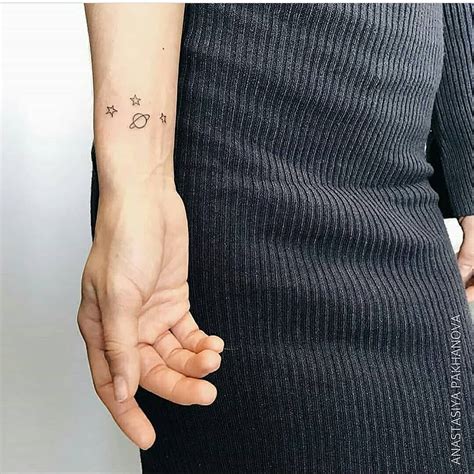 Small Saturn And Three Stars Tattoo On The Right Inner Wrist By