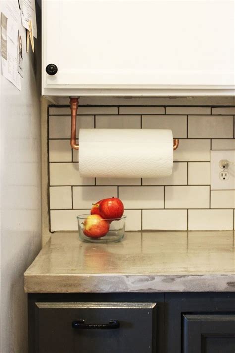 Instead of the flimsy paper towel holder, you could use a hole saw and drill holes up top to run a dowel rod through. Under Cabinet Paper Towel Holder - DIY Copper Pipes