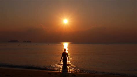 Woman Walking Towards Sunset In The Sea Slow Motion Stock Video