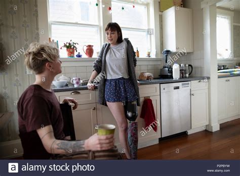 Young Woman Amputee Drinking Coffee Talking With Boyfriend In Kitchen
