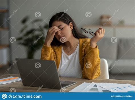 Exhausted Arab Lady Suffering From Headache Using Laptop And Working