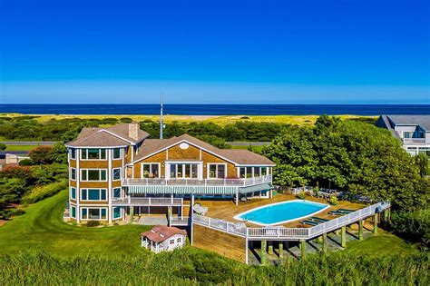 an aerial view of a large house with a pool in the foreground and ocean