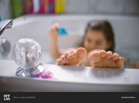 Taking this photo, i could only think that i would drop my. Girl playing in the bathtub with feet on edge of tub stock ...