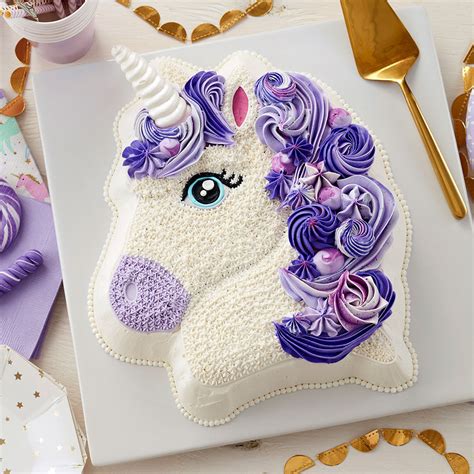 Decorating a cake with butter cream frosting designed with colorful designed swirls including the unicorn head horn made out of fondant icing the eyes on the unicorn are made of piping gel that's painting in eatable gold. Unicorn Cake - Unicorn Birthday Cake | Wilton