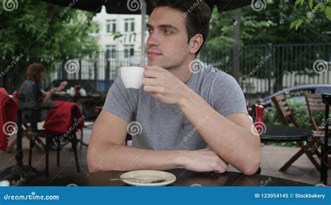 Young Man Drinking Coffee While Sitting In Cafe Terrace Stock Image