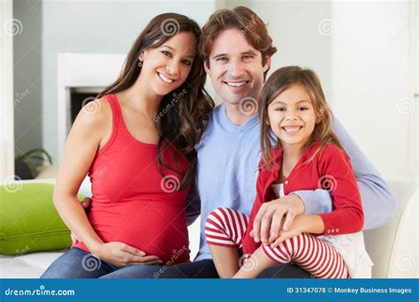 Familia Con La Madre Embarazada Que Se Relaja En Sofa Together Foto De