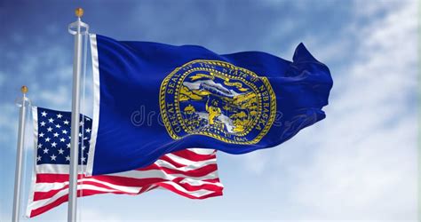 The Nebraska State Flag Waving Along With The National Flag Of The