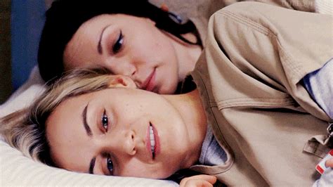 Two Women Laying In Bed With Their Heads On Each Others Shoulders One