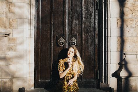Girl With Sunglasses In Vintage Dress Sitting By An Old Door By