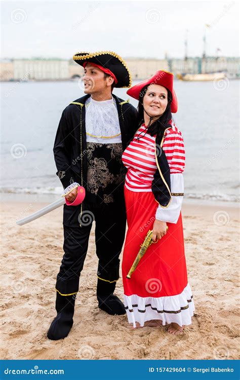 Caucasian Couple In Pirate Costumes Stand Next To Each Other On Sandy