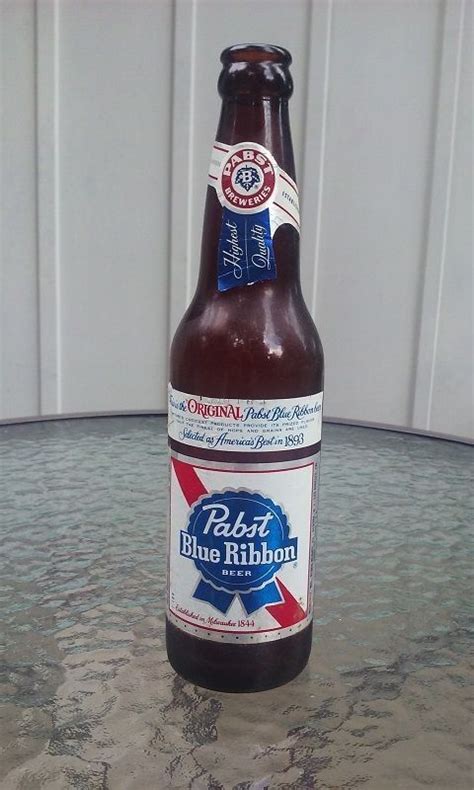 A Bottle Of Beer Sitting On Top Of A Table