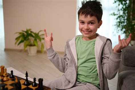 Happy Teenage Boy Smiles Looking At Camera Enjoying Playing Chess Game