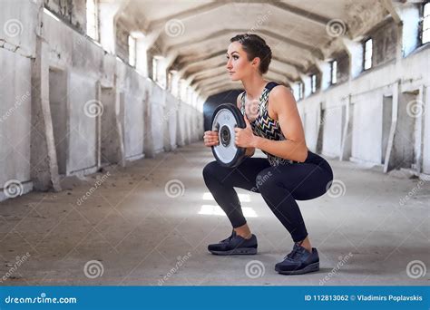 Full Body Portrait Of The Sporty Female Doing Squats Stock Photo