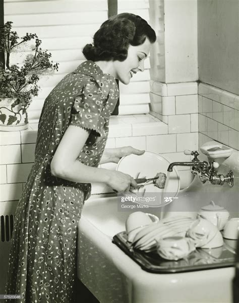 Woman Washing Dishes At Kitchen Sink