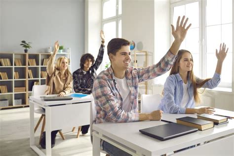 Grupo De Estudiantes De Secundaria O Universitarios Levantando La Mano