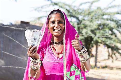 Traditional Indian Rural Rajasthani Woman Holding Money While Showing Thumbs Up In Outdoor