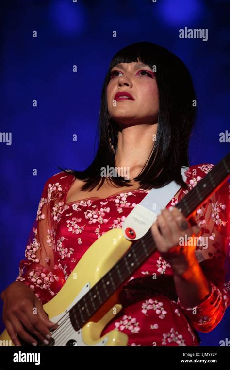 Bassist Laura Lee Of Khruangbin On Stage Wearing A Red Floral Mini