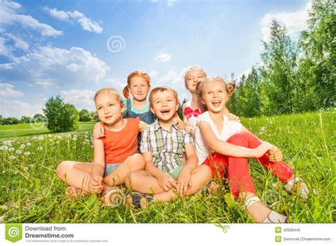 Group Of Children Laugh Sitting On A Grass Stock Image Image Of