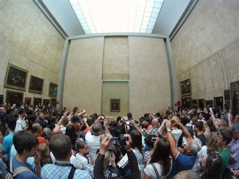 A Large Crowd Of Tourists Trying To See And Take Pictures Of The Mona