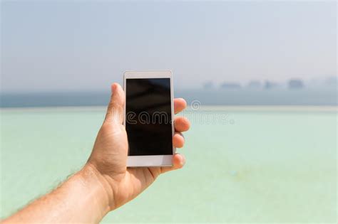 Close Up Of Male Hand Holding Smartphone On Beach Stock Photo Image