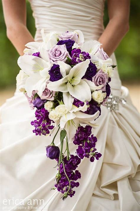 a bride holding a purple and white bouquet