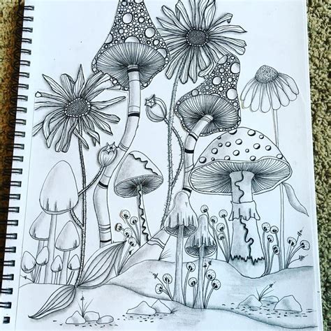 A Drawing Of Flowers And Mushrooms On A Sheet Of Paper With A Pen In It