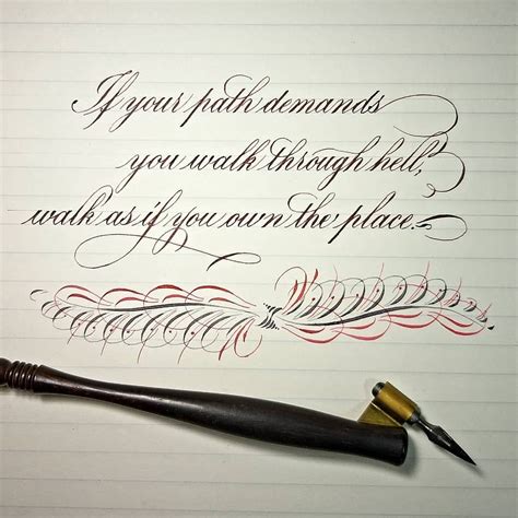 An Ink Pen And Some Writing On Top Of A Piece Of Paper With Calligraphy