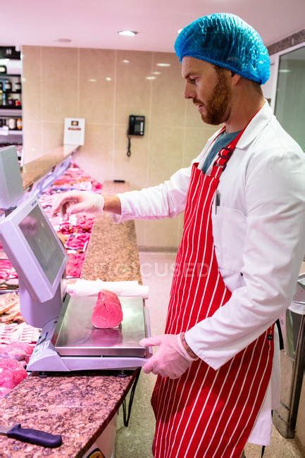 Butcher Checking The Weight Of Meat At Counter In Meat Shop Industry
