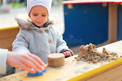 Autumn Little Girl Making Sand Figures In A Children Sandbox Stock