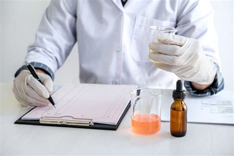 Scientist Or Medical In Lab Coat Holding Test Tube With Reagent Mixing