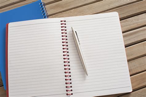 Free Image Of Pen On Open Spiral Notebook On Top Of Wooden Table