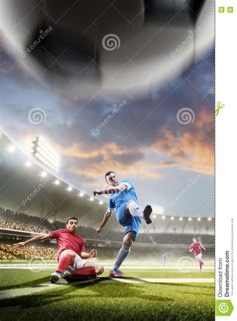 Soccer Players In Action On Sunset Stadium Background Stock Photo
