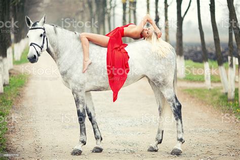 Beautiful Girl In A Red Dress Riding On White Horse Stock