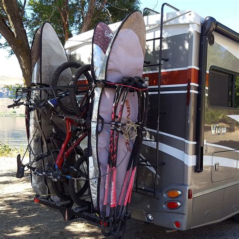 Two Surfboards Are Attached To The Back Of An Rv With Bicycles Strapped