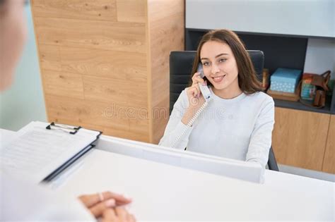 Joyous Young Female Receptionist In Her Workplace Stock Photo Image